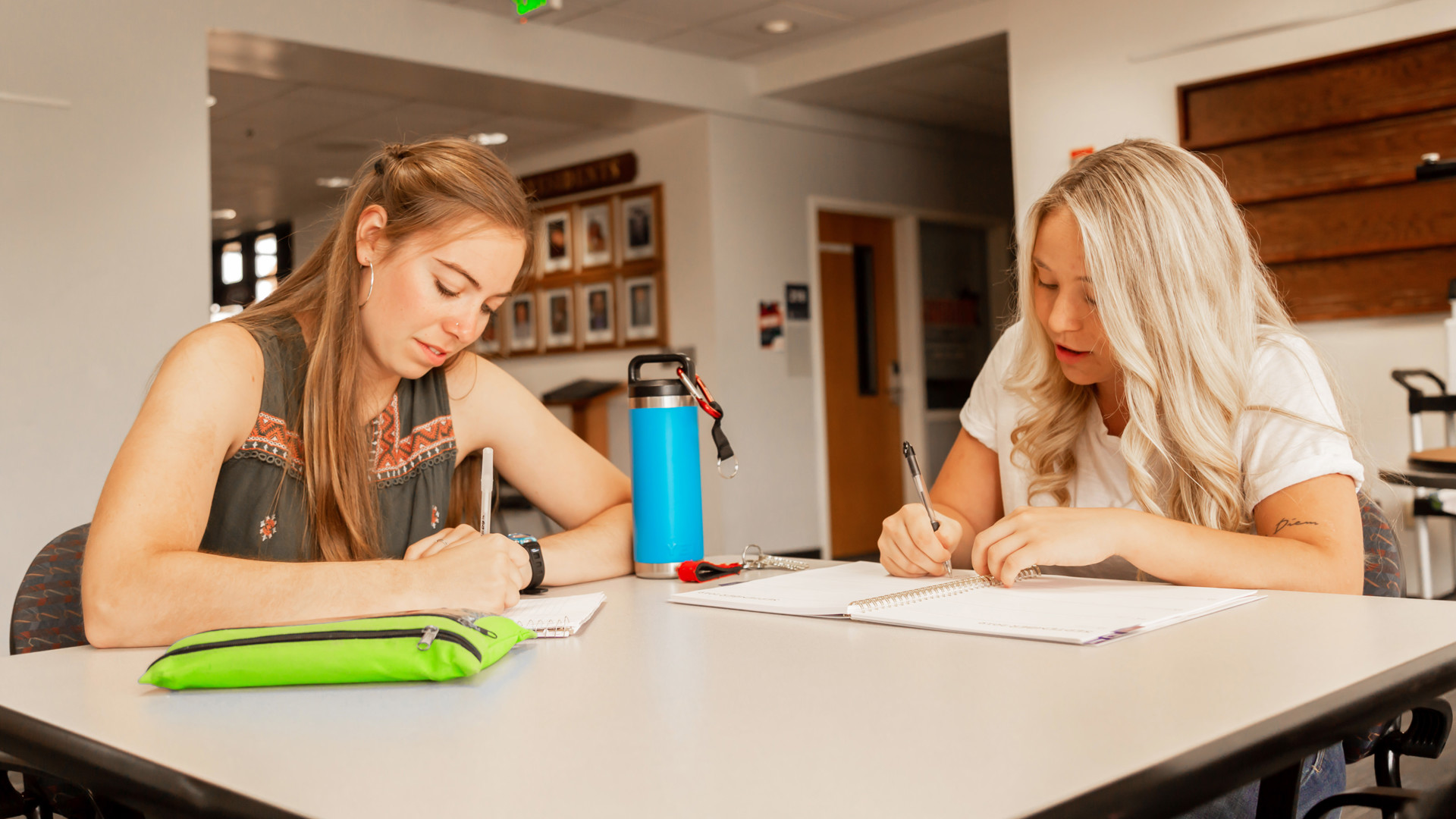 Two students writing at a table